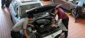 2 auto students looking at car's engine